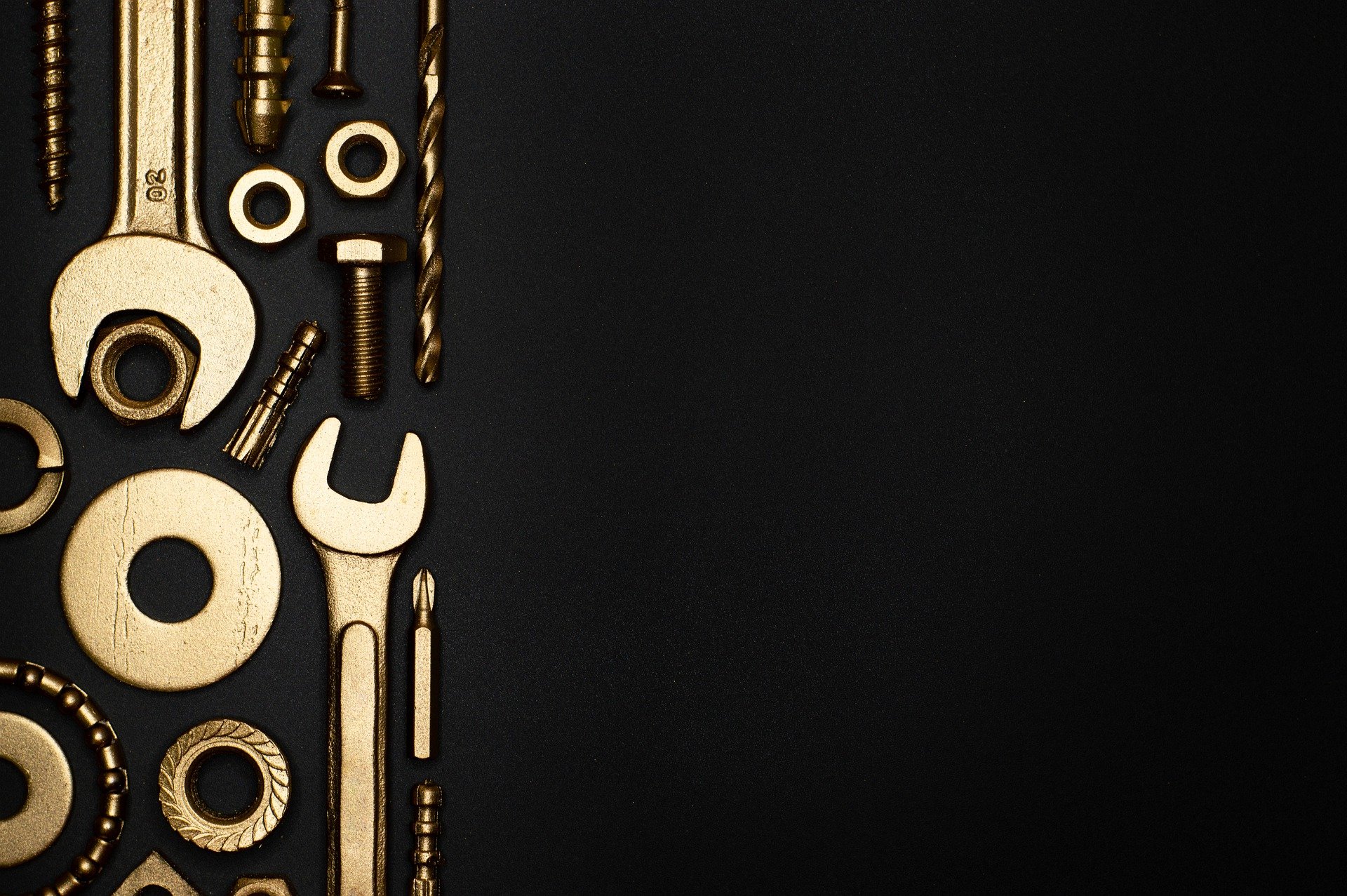 top view of engineering maintenance and repair tools like a wrench, bolt, etc on black surface